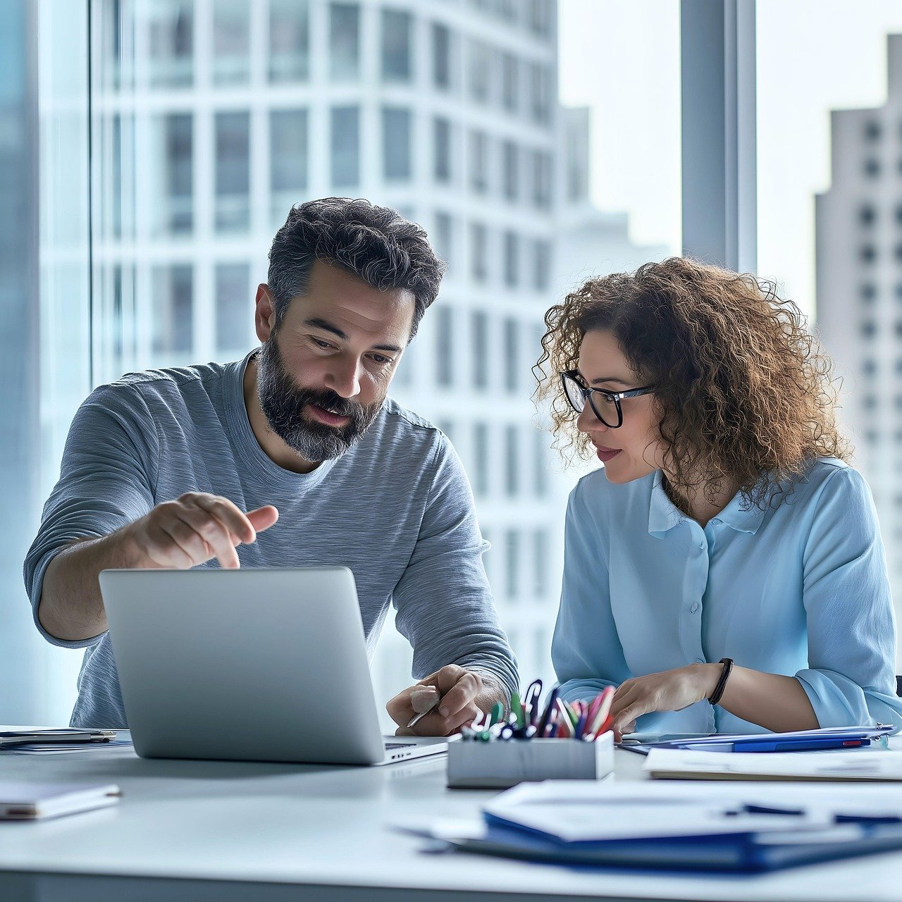 Professionals reviewing an AI workflow on a laptop for human approval and oversight